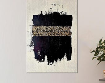 May include: Abstract art canvas with a textured off-white background. A large black brushstroke dominates the center, with a horizontal band of gold calligraphy. The artwork is displayed on a white wall, with a glimpse of a sofa and a plant shelf.