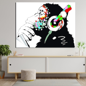 May include: A black and white illustration of a monkey wearing headphones with colorful paint splatters on its face. The monkey is looking to the side and has its hand on its chin.