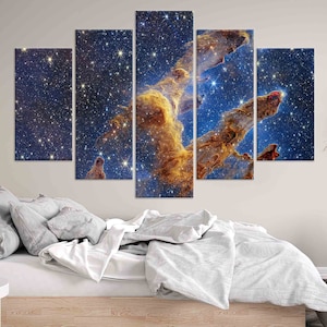 May include: A five-piece canvas print set featuring a nebula with a bright, golden-orange cloud formation against a dark blue background with scattered stars.