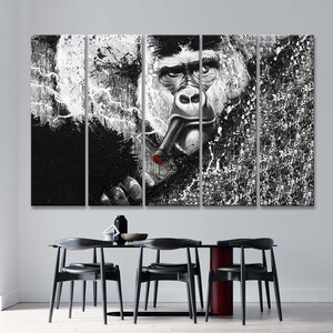 May include: A black and white multi-panel canvas print featuring a gorilla smoking a cigar. The gorilla's face is in the center of the print, and the background is a splatter of white paint on a black background.