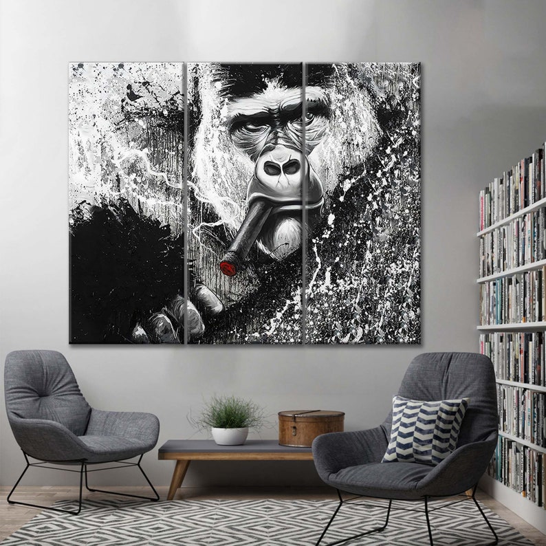 May include: A black and white abstract art print of a gorilla smoking a cigar. The gorilla's face is in the center of the print, and the background is a splatter of white paint on a black background.