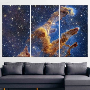 May include: A three-panel canvas print featuring a vibrant nebula with swirling clouds of gas and dust in shades of gold and blue against a backdrop of twinkling stars.