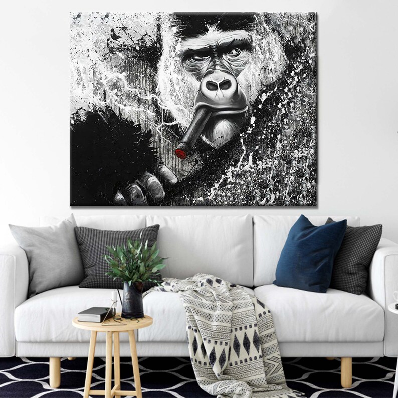 May include: A black and white painting of a gorilla smoking a cigar. The gorilla's face is close-up and the background is a splatter of white paint on black.
