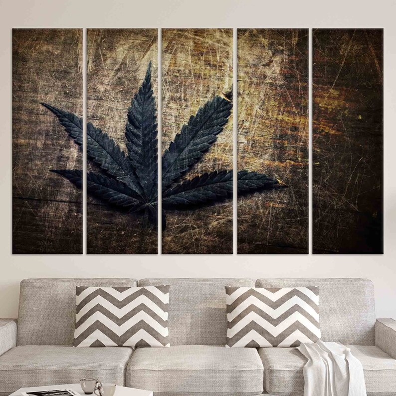 Puede incluir: Una hoja de marihuana verde oscuro sobre un fondo de madera desgastado. La hoja est&aacute; centrada en la imagen y es el foco principal. El fondo de madera es marr&oacute;n oscuro con un aspecto desgastado y desgastado.