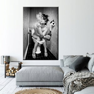 May include: Black and white framed print of a person sitting on a toilet, smoking a cigarette, and holding a bottle. The person is wearing sunglasses and curlers. The bathroom has a roll of toilet paper.