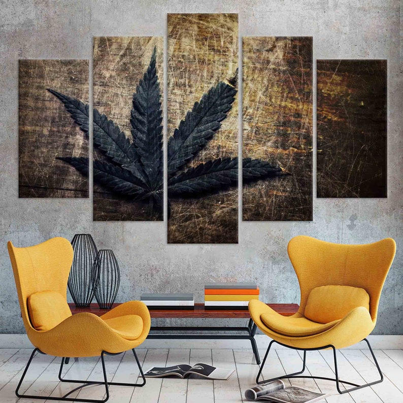Puede incluir: Un conjunto de cinco impresiones en lienzo que presenta una hoja de marihuana verde oscuro sobre un fondo de madera desgastado.