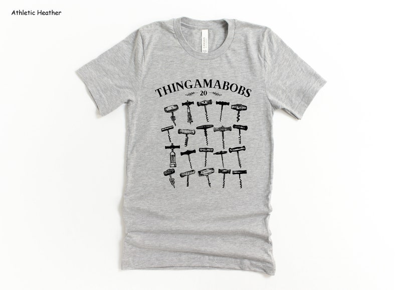 May include: A gray t-shirt with a black graphic of various types of corkscrews. The text "Thingamabobs 20" is printed above the corkscrews.
