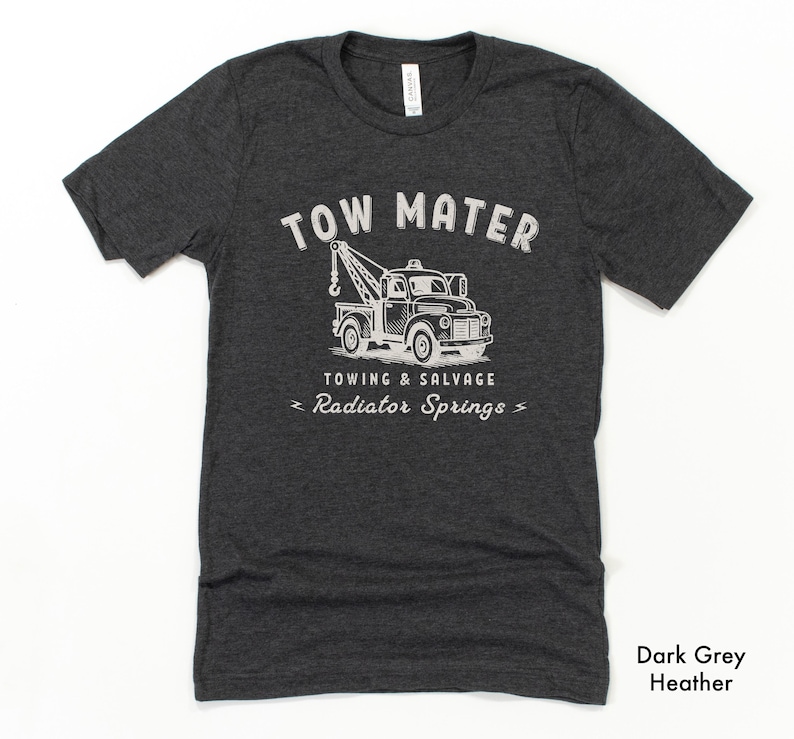 Pu&ograve; includere: T-shirt grigio scuro m&eacute;lange con grafica bianca di un carro attrezzi e la scritta "TOW MATER TOWING & SALVAGE RADIATOR SPRINGS". La maglietta &egrave; girocollo e ha maniche corte.