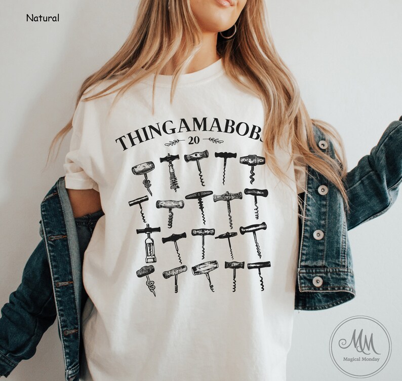 May include: A white t-shirt with a black graphic of the text "Thingamabob 20" and a collection of vintage corkscrews.