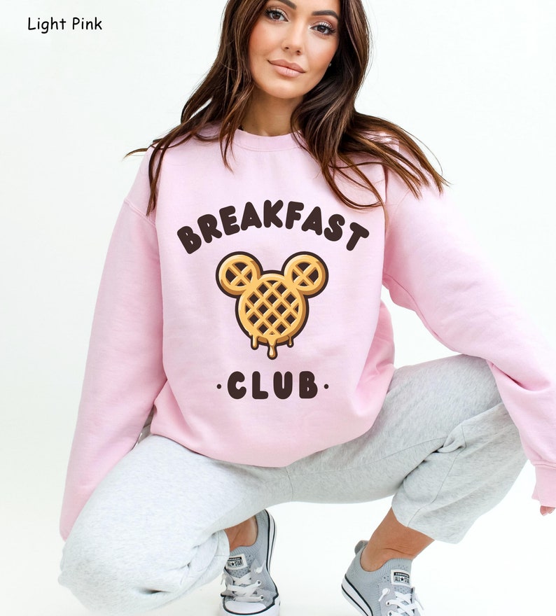 May include: Light pink sweatshirt with a waffle Mickey Mouse graphic and the text "Breakfast Club".