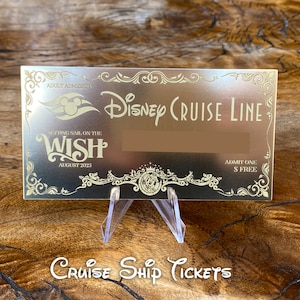 Puede incluir: Un billete de crucero Disney Cruise Line de color dorado con fondo blanco. El billete dice "Setting sail on the Wish" y "August 2023".
