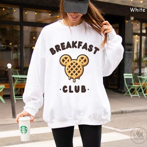 May include: White sweatshirt with a waffle Mickey Mouse design and the text "Breakfast Club".
