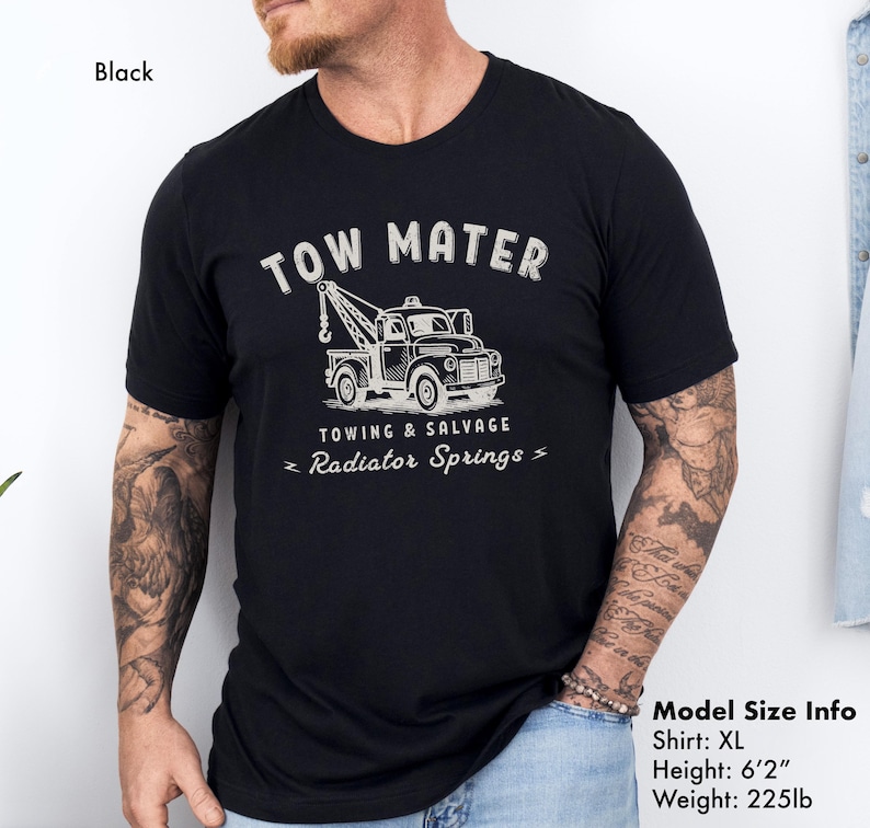 Pu&ograve; includere: T-shirt nero taglia XL con grafica di un carro attrezzi e la scritta "TOW MATER" sopra, con "TOWING & SALVAGE" e "Radiator Springs" sotto. La maglietta &egrave; realizzata in materiale morbido.