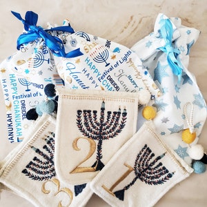 Hanukkah Felt Pocket Banner/Garland in handmade gift bag. Embroidered felt pockets with yellow and blue poms, gold & cream twine.