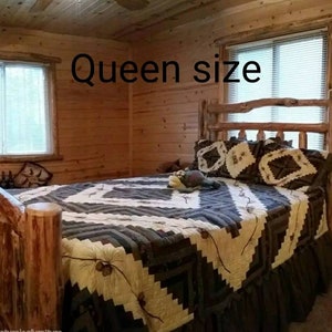 May include: A queen size bed with a rustic log frame and a dark brown and cream geometric patterned quilt. The bedding features a repeating diamond design with pinecone accents. The headboard and footboard are constructed from natural wood logs.