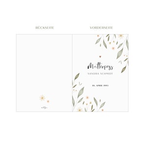 May include: A white card with a floral design and the text "Mutterpass" in black script. The card also includes the text "Sandra Schmidt" and "10. April 1993" in black.