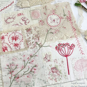 May include: A patchwork quilt with a variety of floral patterns and embroidery. The quilt is made of different fabrics, including linen, lace, and cotton. The quilt features a variety of colors, including pink, red, and green. The quilt is a beautiful example of handmade craftsmanship.
