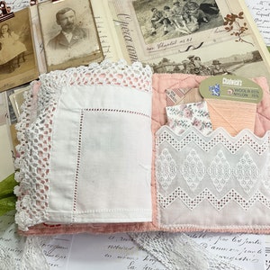 May include: A pink fabric book with a white lace trim and a pocket on the front. The pocket contains a small piece of fabric with a floral pattern and a spool of pink thread. The label on the spool reads "Chadwick's Wool & 88% Nylon 15%".