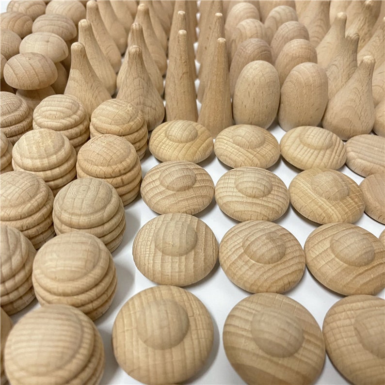 K&ouml;nnte beinhalten: Eine Sammlung von Holzspielzeugformen, darunter Kegel, Zylinder und Scheiben. Die Formen sind alle in nat&uuml;rlicher Holzfarbe und haben eine glatte, polierte Oberfl&auml;che.