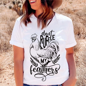 May include: White t-shirt with a black and white illustration of a rooster and the text "don't ruffle my feathers".