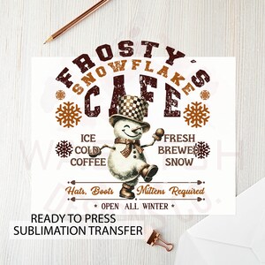 May include: A sublimation transfer design featuring a snowman with a chequered hat and the text "Frosty's Snowflake Cafe" in a distressed font. The design also includes snowflakes and the text "Ice Cold Coffee", "Fresh Brewed Snow", "Hats, Boots, Mittens Required", and "Open All Winter".