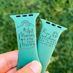 May include: Two teal green Apple Watch bands with inspirational quotes. The left band says "His Mercies are new every morning" with the scripture reference "Lamentations 3:23". The right band says "Rise and shine & give God the glory" with the scripture reference "Isaiah 60:1".