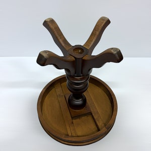 May include: A dark brown wooden table base with a round tabletop and a central pedestal. The base has a star-shaped support structure and a circular tabletop, showcasing a classic design. The table base is suitable for a small table.