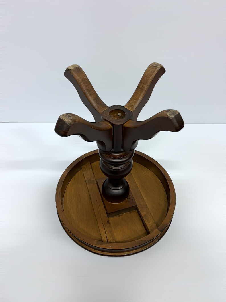 May include: A dark brown wooden table base with a round tabletop and a central pedestal. The base has a star-shaped support structure and a circular tabletop, showcasing a classic design. The table base is suitable for a small table.