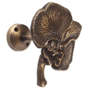 May include: Brass orchid flower curtain tieback with a detailed design. The tieback has a round base with two screw holes for mounting.