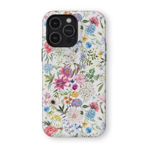 May include: A white phone case with a floral pattern. The case features a variety of colorful flowers, including pink, purple, blue, and yellow. The case has a cutout for the phone's camera.