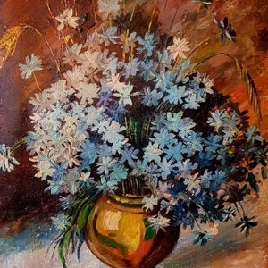 Könnte beinhalten: Ein Stillleben mit einem Strauß blauer und weißer Blumen in einer braunen Keramikvase. Die Blumen sind kreisförmig angeordnet und die Vase steht auf einer weißen Oberfläche. Der Hintergrund ist braun und orange.