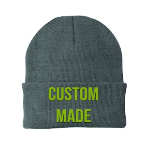May include: A grey beanie with the words "CUSTOM MADE" in green lettering.