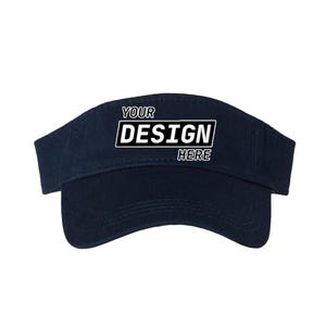 Puede incluir: Visera azul marino con el texto "YOUR DESIGN HERE" en un rectángulo blanco y negro. La visera tiene una visera curva y una banda de tela. Adecuada para actividades al aire libre.