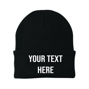 May include: Black knitted beanie with white text that reads "YOUR TEXT HERE".