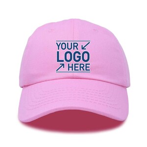 Puede incluir: Gorra de béisbol rosa con una caja bordada en blanco que dice "YOUR LOGO HERE" en texto azul.