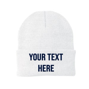 May include: White knitted beanie with the text "YOUR TEXT HERE" in navy blue.
