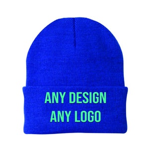 May include: A blue knitted beanie with the text "ANY DESIGN ANY LOGO" in green.