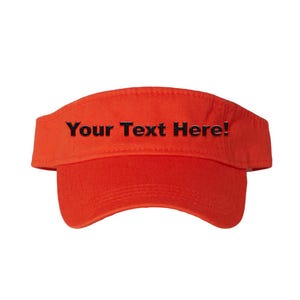 Op de afbeelding: Fel oranje vizier met de tekst "Your Text Here!" in zwart. Het vizier heeft een gebogen klep en een band die rond het hoofd gaat. Dit accessoire is ontworpen om de ogen tegen de zon te beschermen.