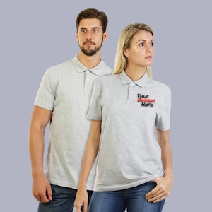 May include: Two gray polo shirts, one with the text "Your Design Here" in red and black lettering.