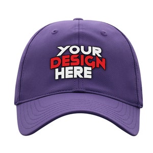 Op de afbeelding: Een paarse baseballpet met de tekst "YOUR DESIGN HERE" in witte en rode letters.