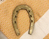 Vintage gold painted cast iron horseshoe wall hanging with rustic markings, good luck keepsake, farmhouse decor