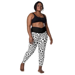 May include: Black and white leggings with a soccer ball pattern. The leggings have a high waist and a black waistband.