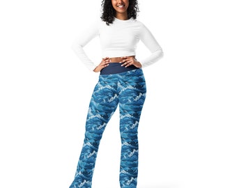 May include: A woman wearing a white long-sleeved shirt and blue leggings with a wave pattern. The leggings have a dark blue waistband.