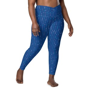 May include: Blue leggings with a white and blue binary code pattern. The leggings have a high waist and a criss-cross design at the waistband.