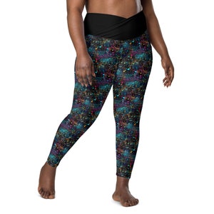 May include: Black leggings with a colorful abstract pattern of lines and dots. The leggings have a wide black waistband that wraps around the waist.