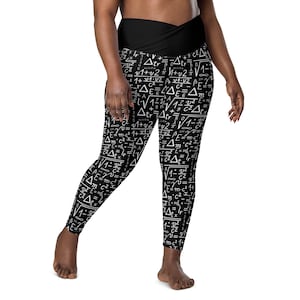 May include: Black leggings with a white print of mathematical equations and formulas. The leggings have a wide waistband.