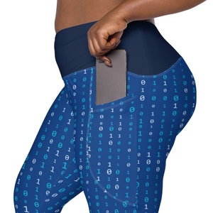 May include: Blue leggings with a pattern of 0s and 1s. The leggings have a pocket on the right side with a black smartphone inside.