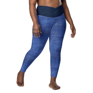 May include: Blue denim leggings with a wide, navy blue waistband that wraps around the waist.