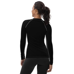 May include: Black long-sleeve shirt with gray trim around the neckline and sleeves. The shirt is fitted and has a crew neck.