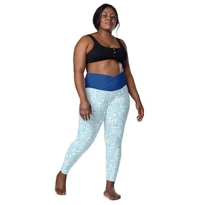 May include: A woman wearing a black sports bra and blue and white leggings with a circuit board pattern. The leggings have a wide blue waistband.